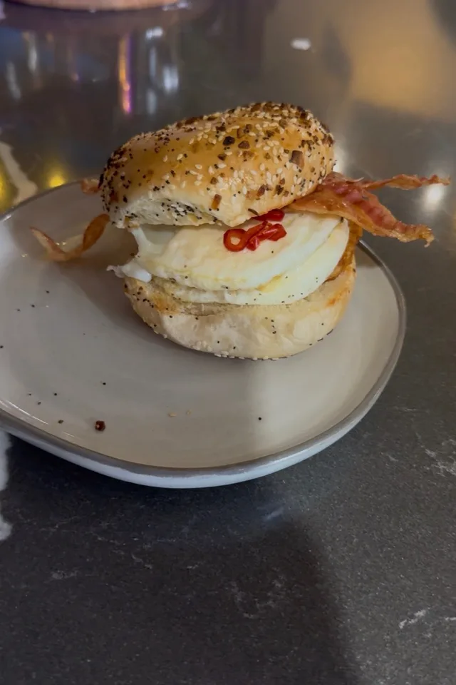 Breakfast bagel with egg, bacon and chili