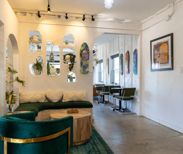 Green velvet lounge seating with skate decks and plants